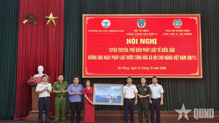 Đại tá Doãn Ngọc Triết, Phó tư lệnh Pháp luật Bộ tư lệnh Vùng Cảnh sát biển 2 trao quà lưu niệm tặng đại diện Trường Đại học Quảng Nam.