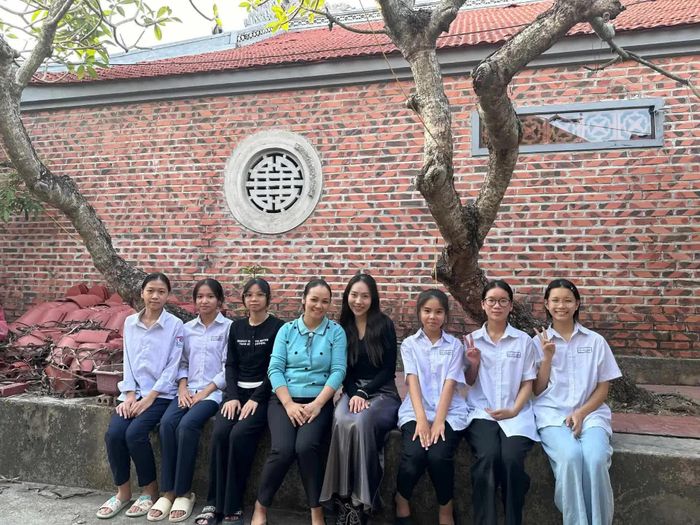 Vũ Minh Anh (thứ tư từ phải sang) chụp ảnh cùng nghệ sĩ ca trù Phạm Thị Liên (áo xanh dương, thứ tư từ trái sang) và các em nhỏ trong chuyến tìm hiểu nghệ thuật ca trù tại Hải Phòng, tháng 11/2024. (Ảnh: NVCC)
