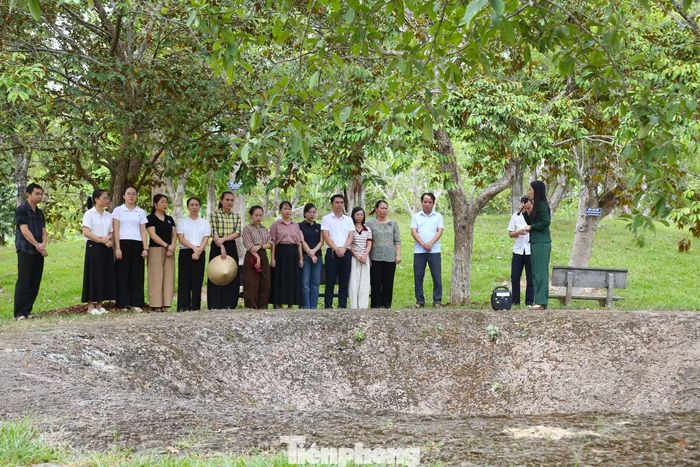 Du khách nghe thuyết minh về sự hy sinh anh dũng của 13 liệt sĩ TNXP bên hố bom tại Khu di tích quốc gia Truông Bồn.