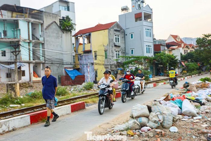 Đất đá, vật liệu xây dựng và rác thải tập kết ngổn ngang sát đường dân sinh, ảnh hưởng đến cảnh quan và gây khó khăn cho việc đi lại của người dân.