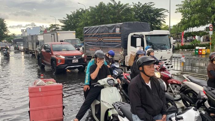 Người dân di chuyển vất vả sau cơn mưa lớn