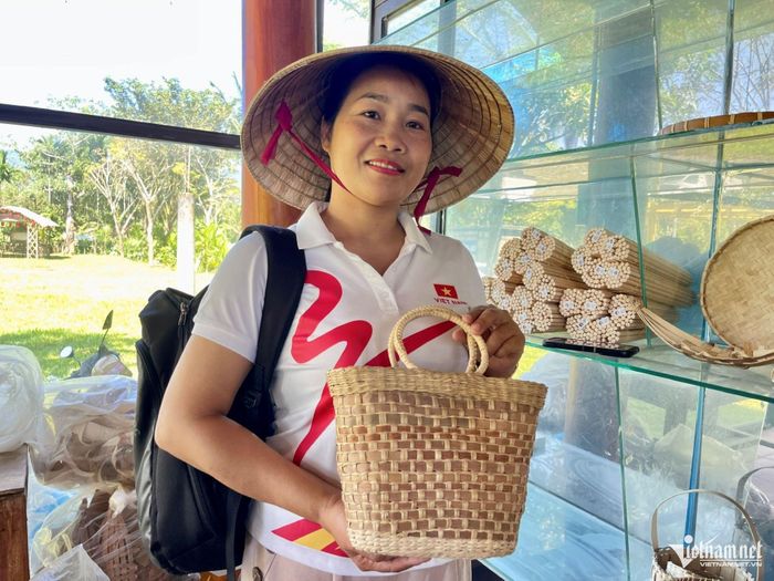Bà Võ Thị Thu Thôi giới thiệu sản phẩm cho du khách tại nhà trưng bày. Ảnh: Huy Trường