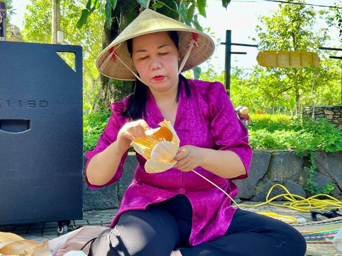 Bà Đào Thị Hồng Niên đang làm hoa sen từ mo cau. Ảnh: Huy Trường