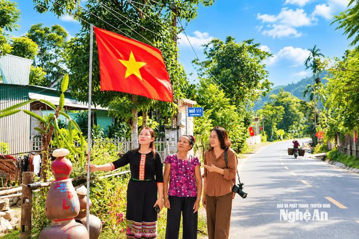 Người dân bản Đôm phấn khởi giới thiệu cho khách về việc xây dựng nếp sống văn hóa, văn minh "nhà có số, ngõ có tên" ở bản. Ảnh: T.P