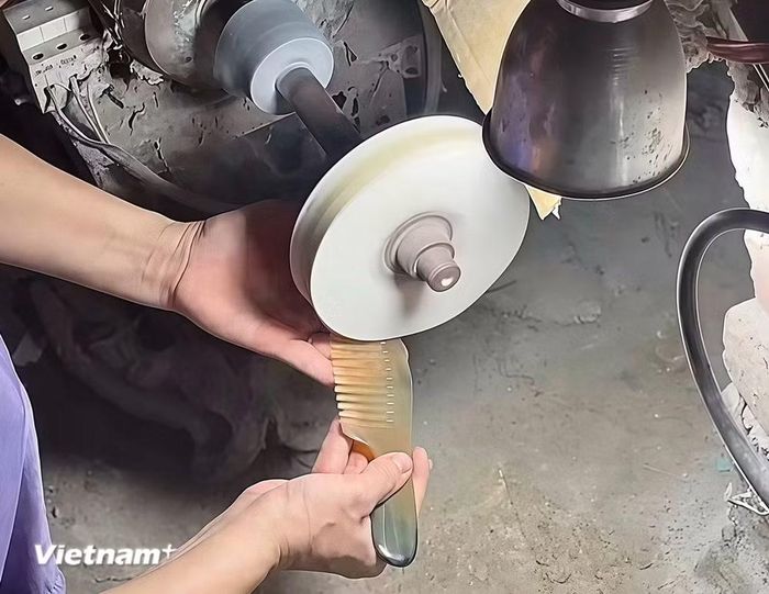 Người thợ sử dụng máy mài để đánh bóng sản phẩm lược sừng một cách tỉ mỉ. (Ảnh: Phương Thảo/Vietnam+)