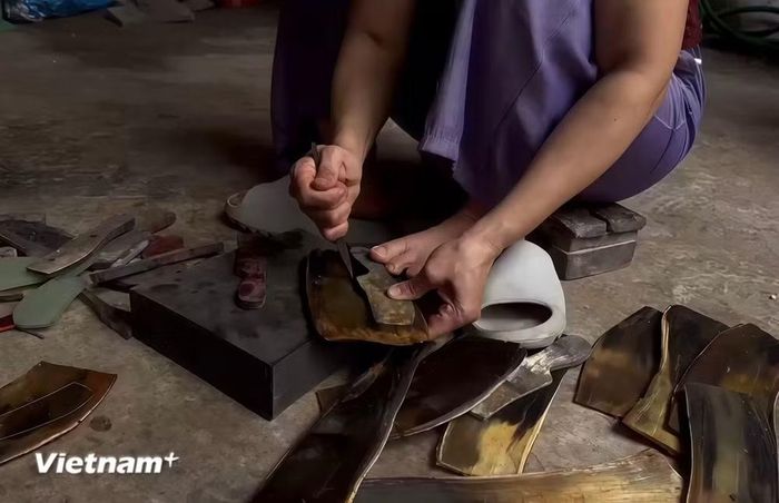 Nghệ nhân miệt mài gọt dũa chiếc lược sừng để sản phẩm đến tay người dùng hoàn thiện nhất. (Ảnh: Phương Thảo/Vietnam+)