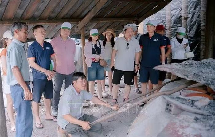 Khách du lịch tham quan, trải nghiệm lò hầm muối ở làng Tuyết Diêm.