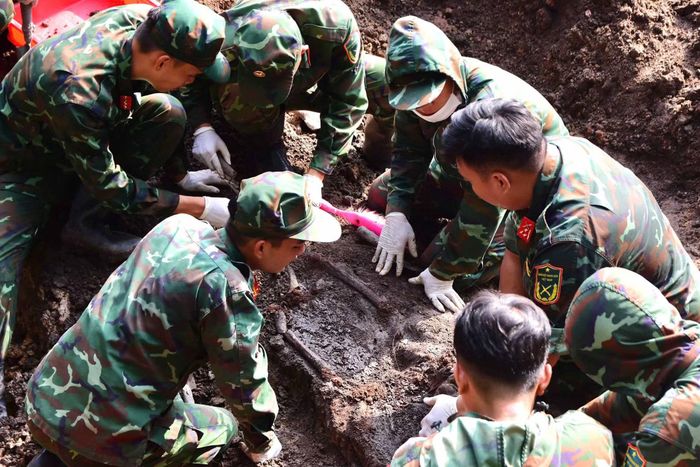 Lực lượng quy tập tỉ mỉ bóc tách từng lớp đất để tìm kiếm hài cốt liệt sĩ.