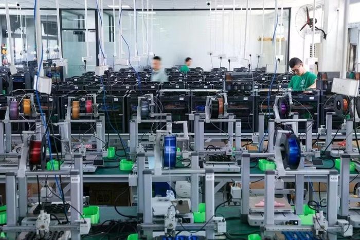 Các công nhân kiểm tra máy móc tại một nhà máy in 3D ở Thâm Quyến. Ảnh: Xinhua.