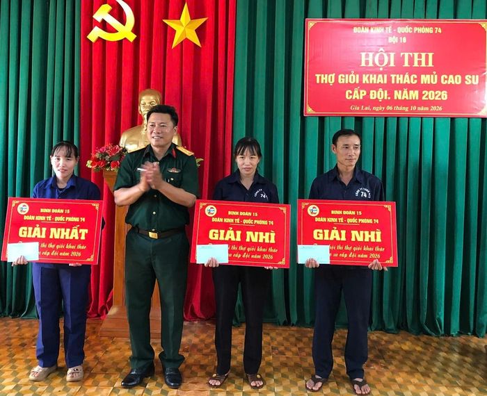 Chị Cao Thị Hạnh (bìa trái) được Thủ trưởng đơn vị trao tặng giải Nhất tại Hội thi thợ khai thác mủ cao su cấp đội, năm 2026.