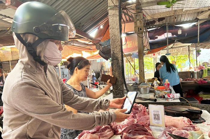 Người dân mua hàng thanh toán không dùng tiền mặt tại chợ Mỹ Cầu, phường Đa Mai.