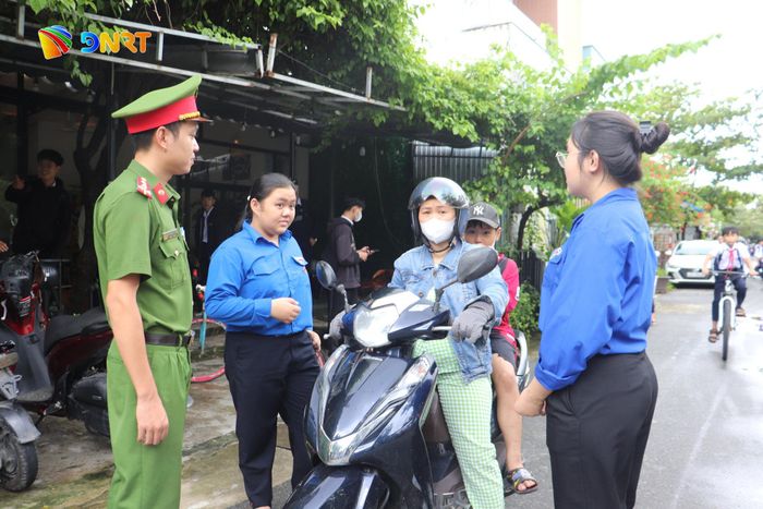Lực lượng Công an, thanh niên tình nguyện hướng dẫn phụ huynh dừng, đỗ xe đúng quy định. Ảnh: KHÁNH NGÂN