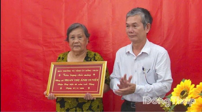 Phó Chủ tịch Thường trực Ủy ban MTTQ Việt Nam tỉnh Đinh Văn Dũng trao Huy hiệu 60 năm tuổi Đảng cho đảng viên Phan Thị Ánh Tuyết. Ảnh: VĂN ĐẤU
