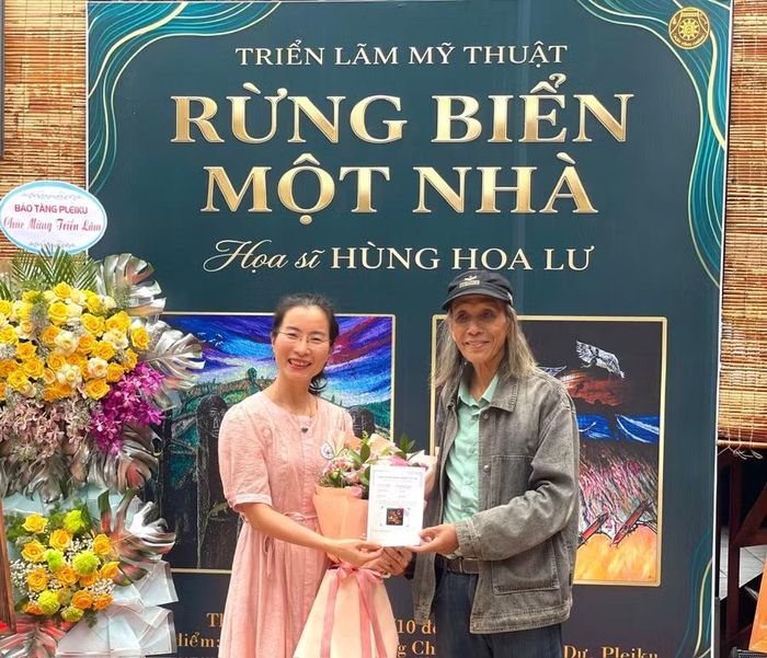Nghệ sĩ Hùng Hoa Lư trao giấy chứng nhận quyền tác giả đối với tác phẩm "Sắc thắm hoa Pơ lang" cho người sưu tập. Ảnh: Phương Duyên