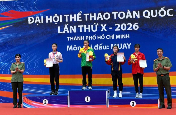 VĐV Hứa Thị Kim Thu (áo đỏ bục 3) nhận huy chương đồng hạng cân 48 kg
