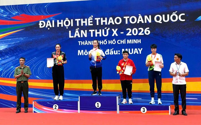 VĐV Nông Thị Kiều Trinh (áo đỏ bục 3) nhận huy chương đồng nội dung đối kháng hạng cân 63,5kg