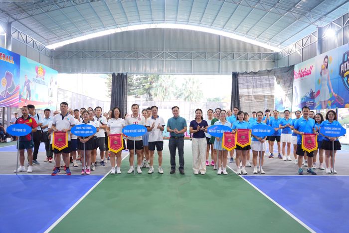 Đại diện Ban Tổ chức trao cờ lưu niệm cho các đoàn vận động viên