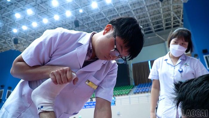 Nhân viên y tế sơ cứu, hỗ trợ vận động viên Nguyễn Quang Huy sau chấn thương.