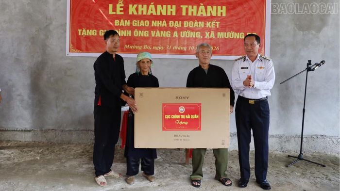Chuẩn đô đốc Hồ Thanh Hoàn - Bí thư Đảng ủy, Phó Chủ nhiệm Cục Chính trị Hải quân, trao quyết định hỗ trợ xây dựng nhà và tặng ti vi cho gia đình ông Vàng A Ướng, thôn Thanh Phú, xã Mường Bo.