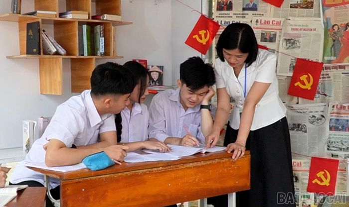  Cô giáo Quyền Thị Thúy Hằng - Phó Hiệu trưởng Trường THPT Sơn Thịnh trao đổi với học sinh trong giờ ngoại khóa. 