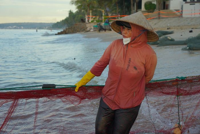 Phụ nữ làng chài ướt sũng sau những mẻ lưới thu về