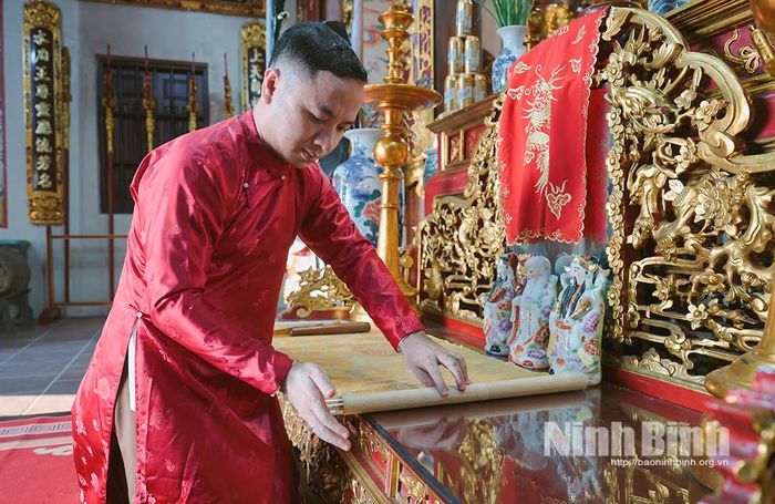 Nghệ nhân Ưu tú Vũ Thanh Bình kiểm tra, bảo quản các đạo sắc phong triều Nguyễn được lưu giữ tại Đền Bảo Ninh. Ảnh: Viết Dư