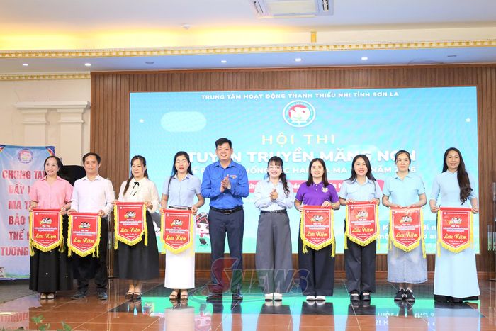 Ban tổ chức trao cờ lưu niệm cho các đội thi.