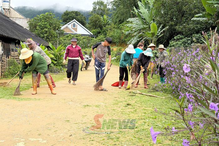 Hội viên Chi hội Phụ nữ bản Hỏm Lợi, xã Mường Chanh quét dọn đường vào bản.
