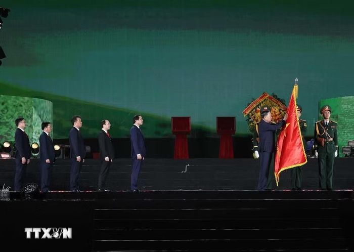 Tổng Bí thư, Chủ tịch nước Tô Lâm thực hiện nghi thức gắn Huân chương Lao động hạng Nhất lên cờ truyền thống của tỉnh Thái Nguyên. Ảnh: TTXVN.