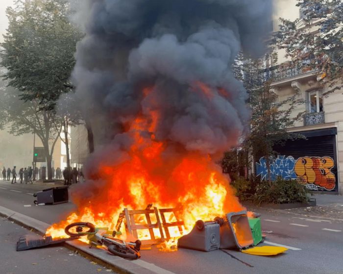 Thùng rác bị đốt bên ngoài trường trung học Voltaire ở quận 11 của Paris trong cuộc biểu tình của học sinh hồi tháng 9. Ảnh: CLPRESS/ABACA/Shutterstock