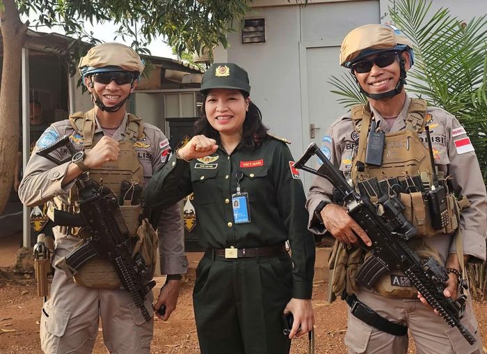 Nhà báo Thu Hòa và 2 thành viên của Tiểu đội FPU Cảnh sát Indonesia hộ tống đoàn.