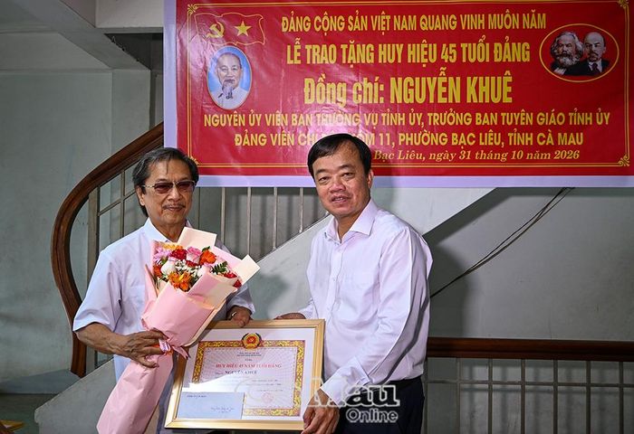 Phó Bí thư Tỉnh uỷ Huỳnh Quốc Việt trao Huy hiệu 45 năm tuổi Đảng và tặng hoa chúc mừng đồng chí Nguyễn Khuê, nguyên Trưởng ban Tuyên giáo Tỉnh uỷ Bạc Liêu.