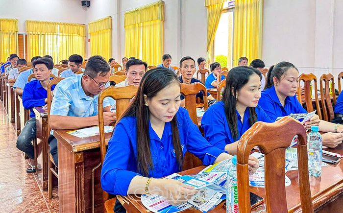  Người lao động địa phương tìm hiểu nhu cầu tuyển dụng của doanh nghiệp qua tờ rơi thông tin.