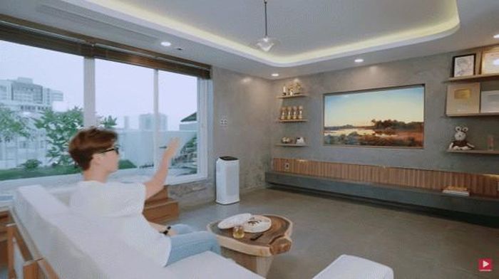 Phòng khách có cửa sổ lớn với tầm nhìn thoáng đãng, nội thất sử dụng tông màu trắng - nâu.
