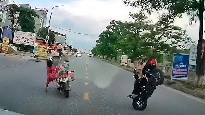 Tạt đầu xe kh&aacute;c để sang đường, xe m&aacute;y điện chở 3 người ng&atilde; nh&agrave;o
